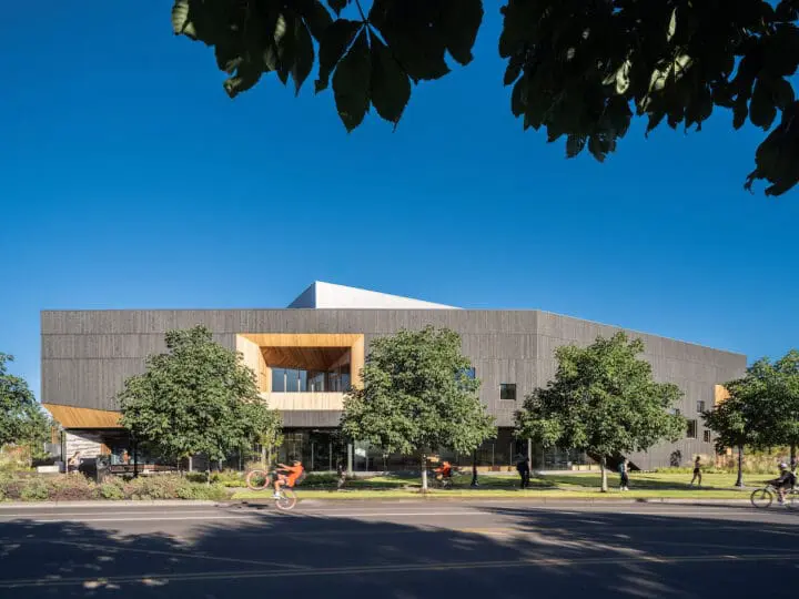 An exterior image of PRAx from across the street of Washington Way that shows the building’s interesting shape, expressed by the dark-stained wood.