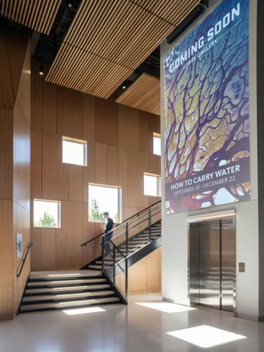 A grand stair case located next to a double sided elevator provides an equal entry experience for all users
