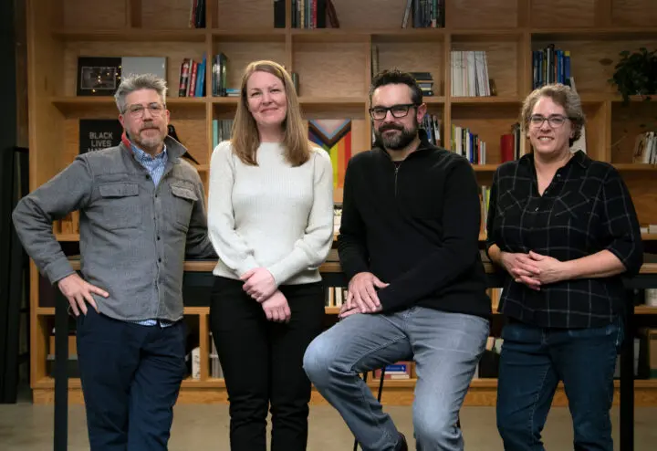 Portrait of Holst's four owners, standing in the Holst office lobby